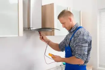 A British boy wearing a gray checks shirt, blue pants, and inspecting the chimney with a multimeter