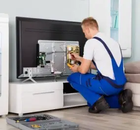 A British man is wearing a white T-shirt, blue pants, and sit down and watch the final part of the TV show.