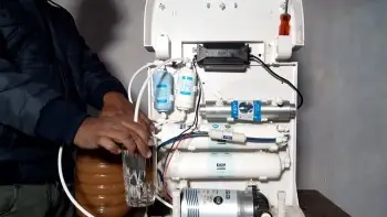 An Indian man is filling water with a water purifier